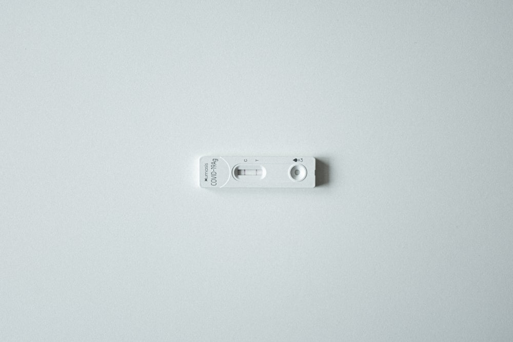 a close up of a remote control on a white surface