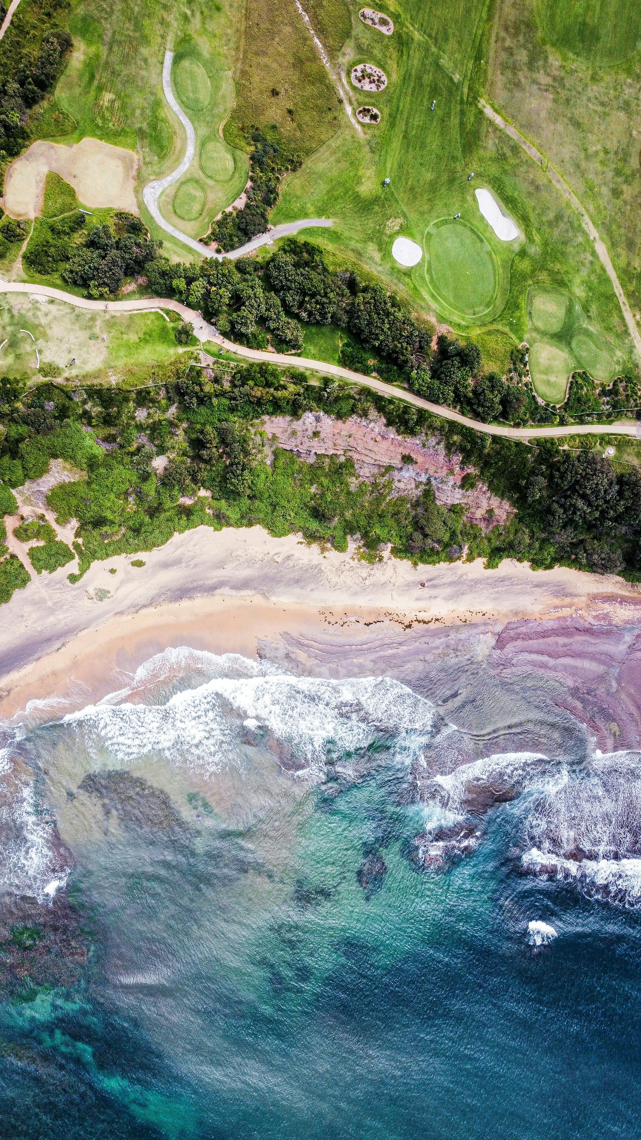 an aerial view of a golf course near the ocean