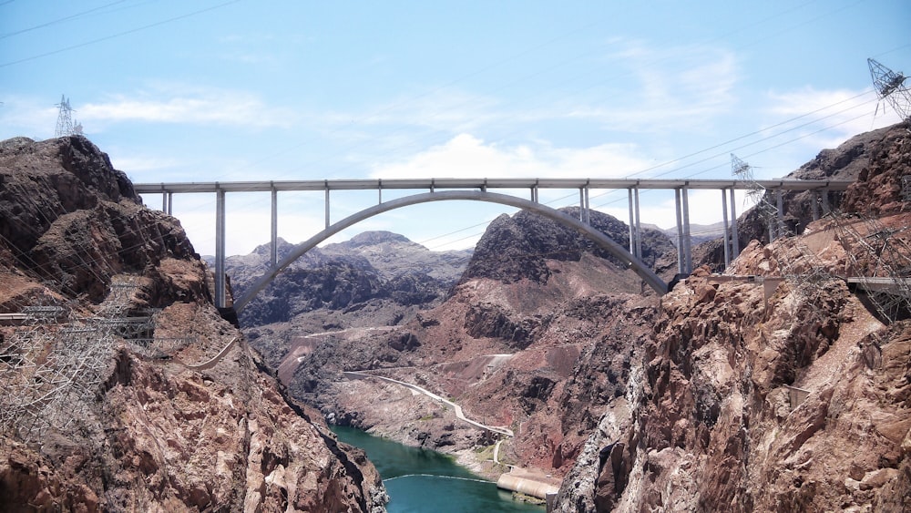 a bridge over a river surrounded by mountains