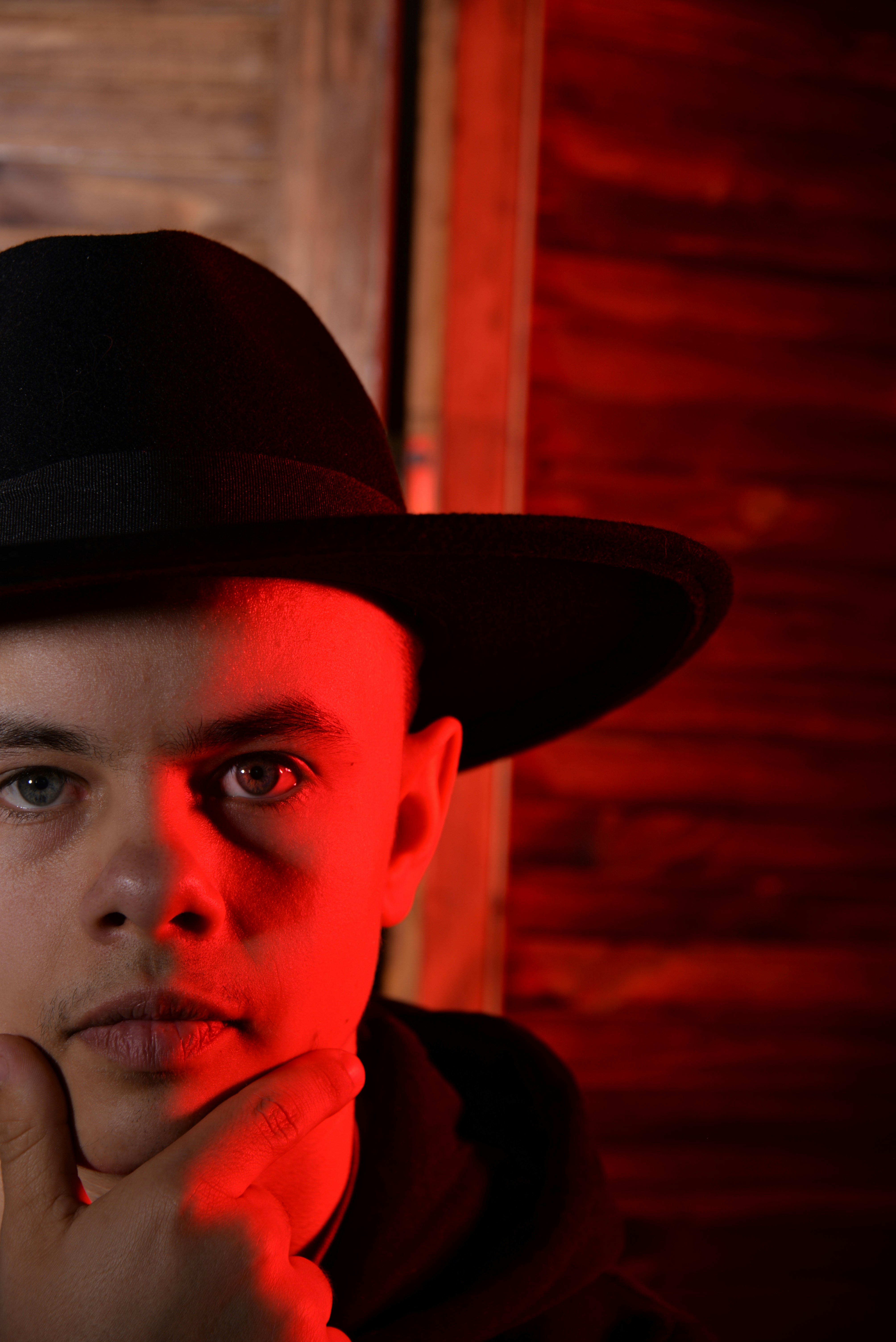 Un joven con un sombrero negro y una luz roja
