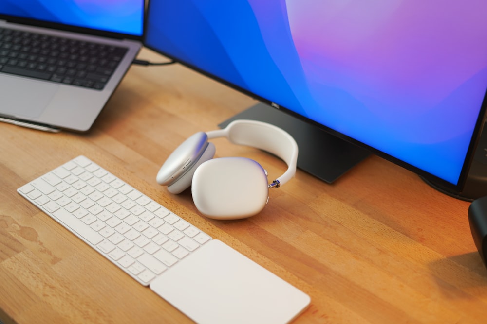 a computer desk with a keyboard, mouse and headphones