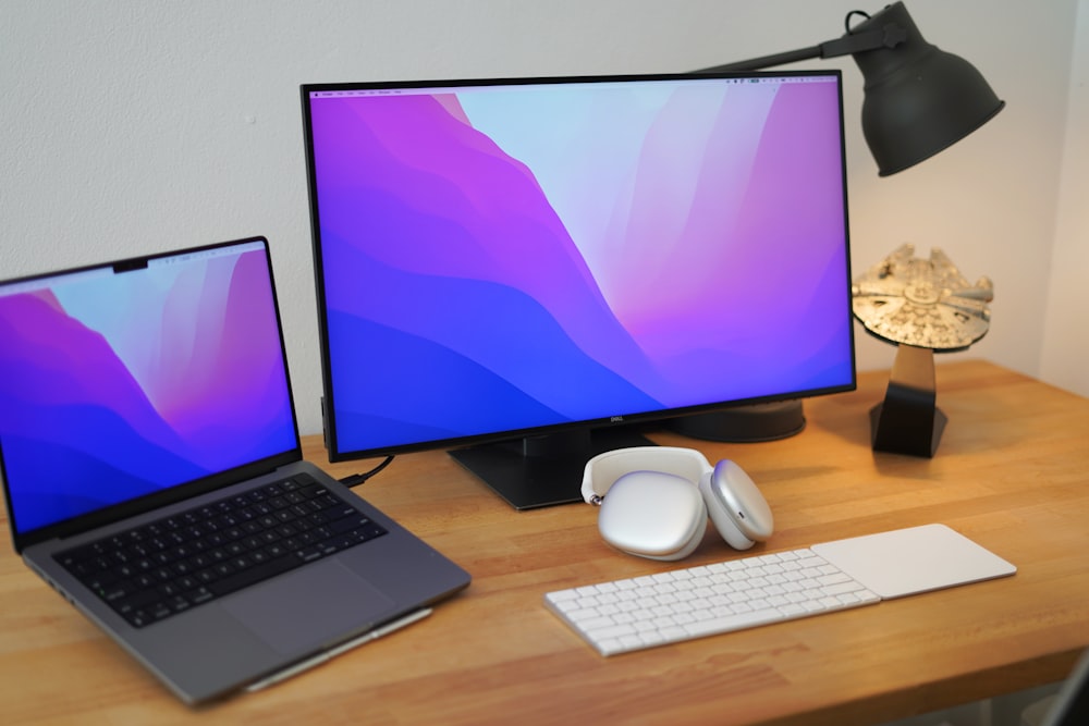 a desk with a laptop and two monitors