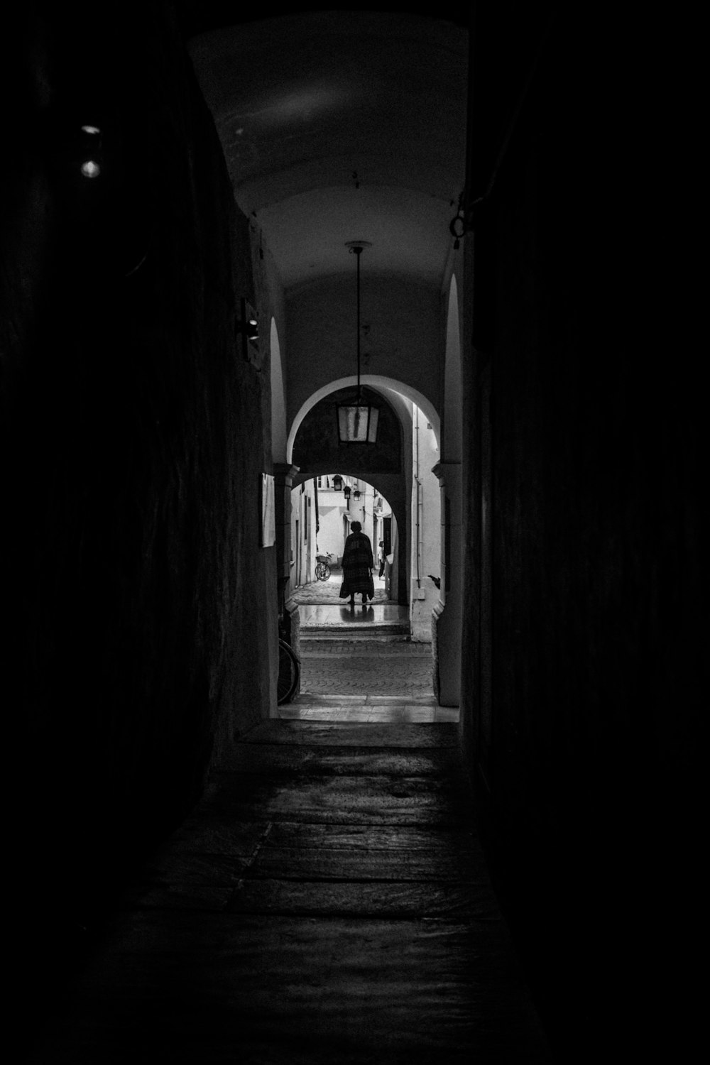 a dark hallway with a person walking down it