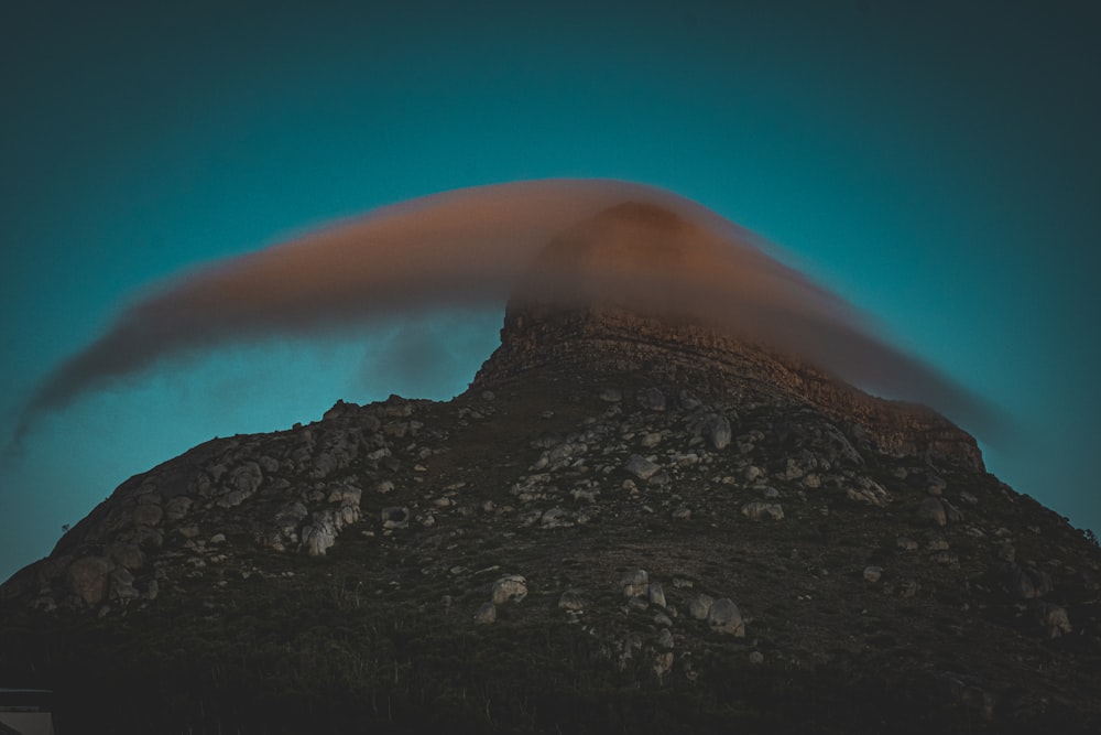 uma montanha com uma nuvem saindo dela