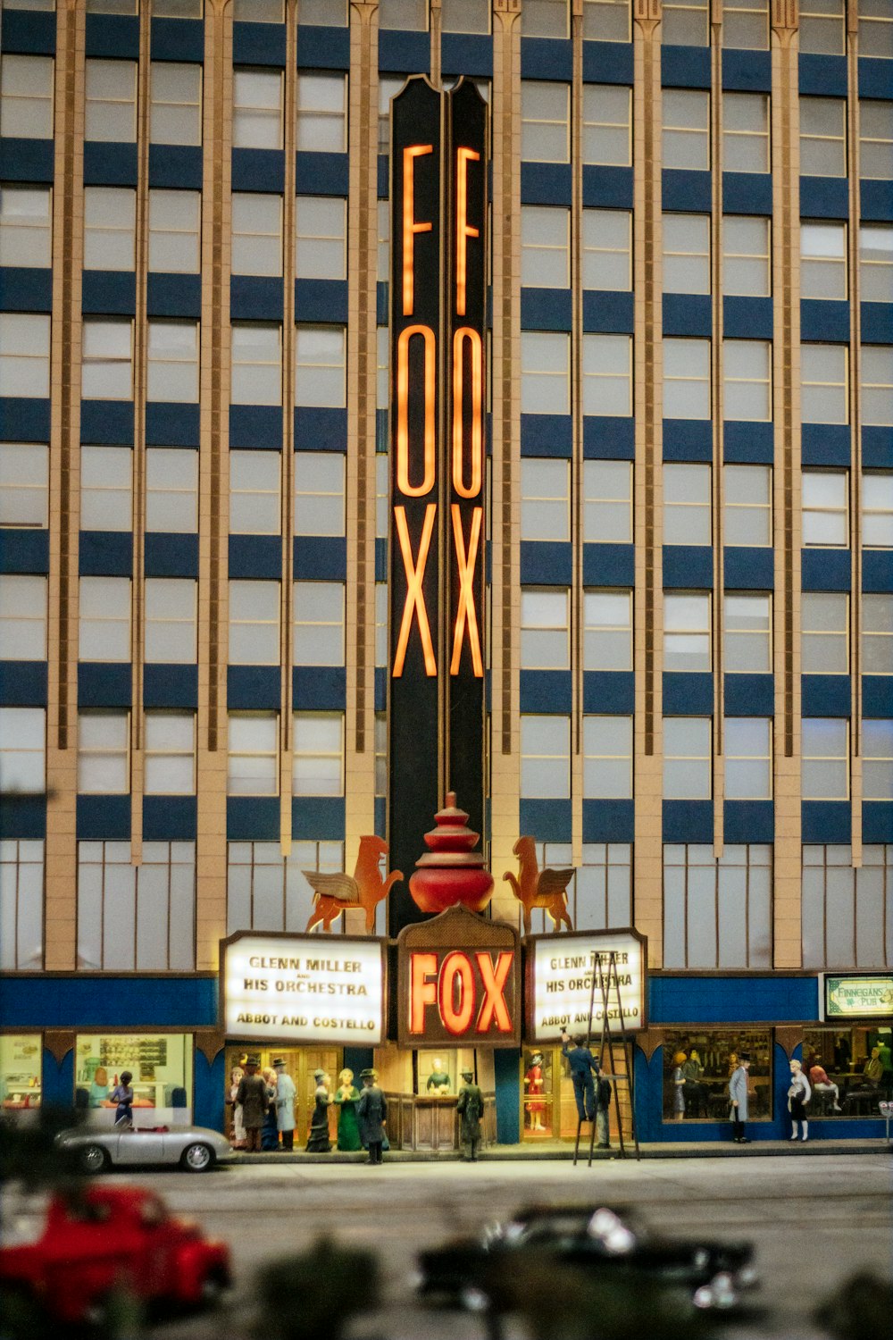 a tall building with a neon sign in front of it