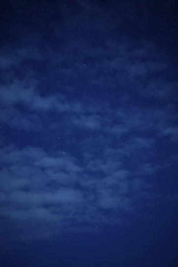 A serene night sky filled with twinkling stars and a glowing tarot card spread beneath.