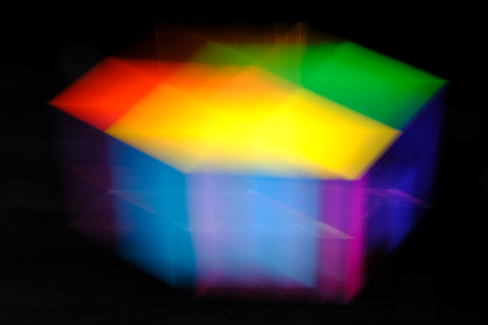 a blurry image of a colorful cube on a black background