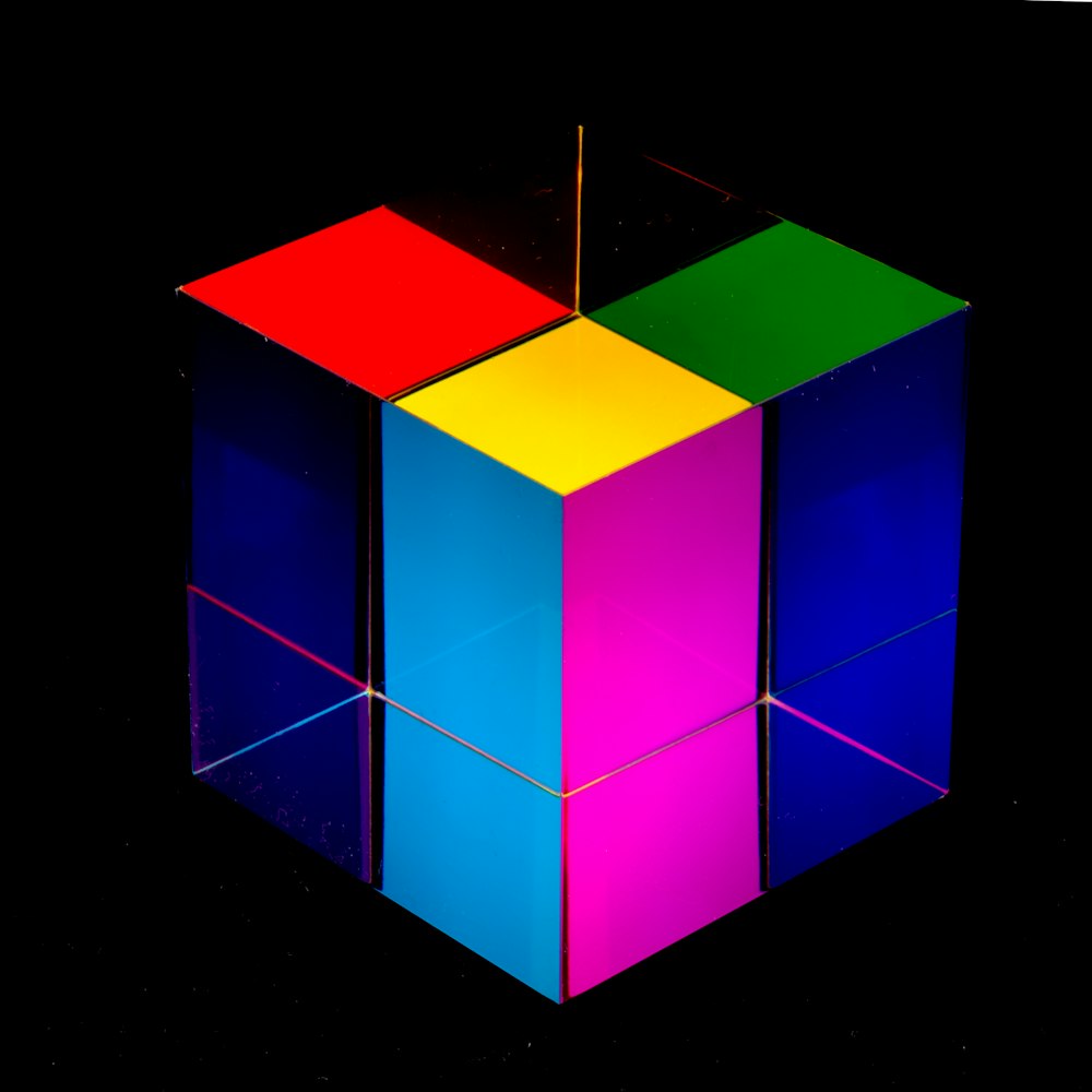Un cubo multicolor sentado encima de una superficie negra