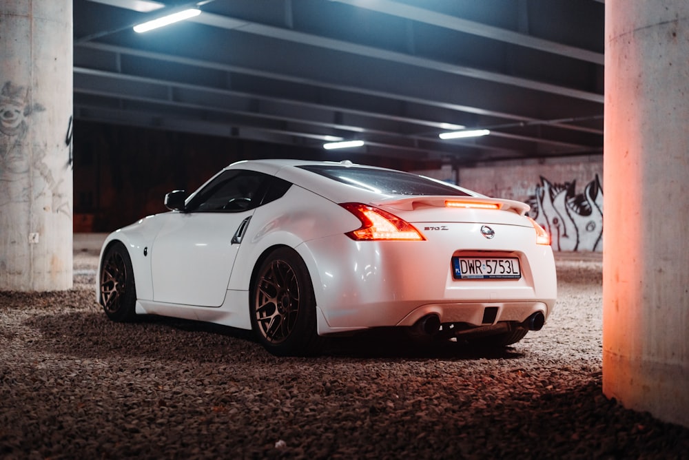 a white sports car parked in a parking garage