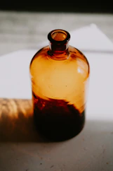 a brown glass bottle sitting on top of a table