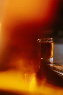 A vibrant shot glass filled with a glowing elixir, ready for a social toast.