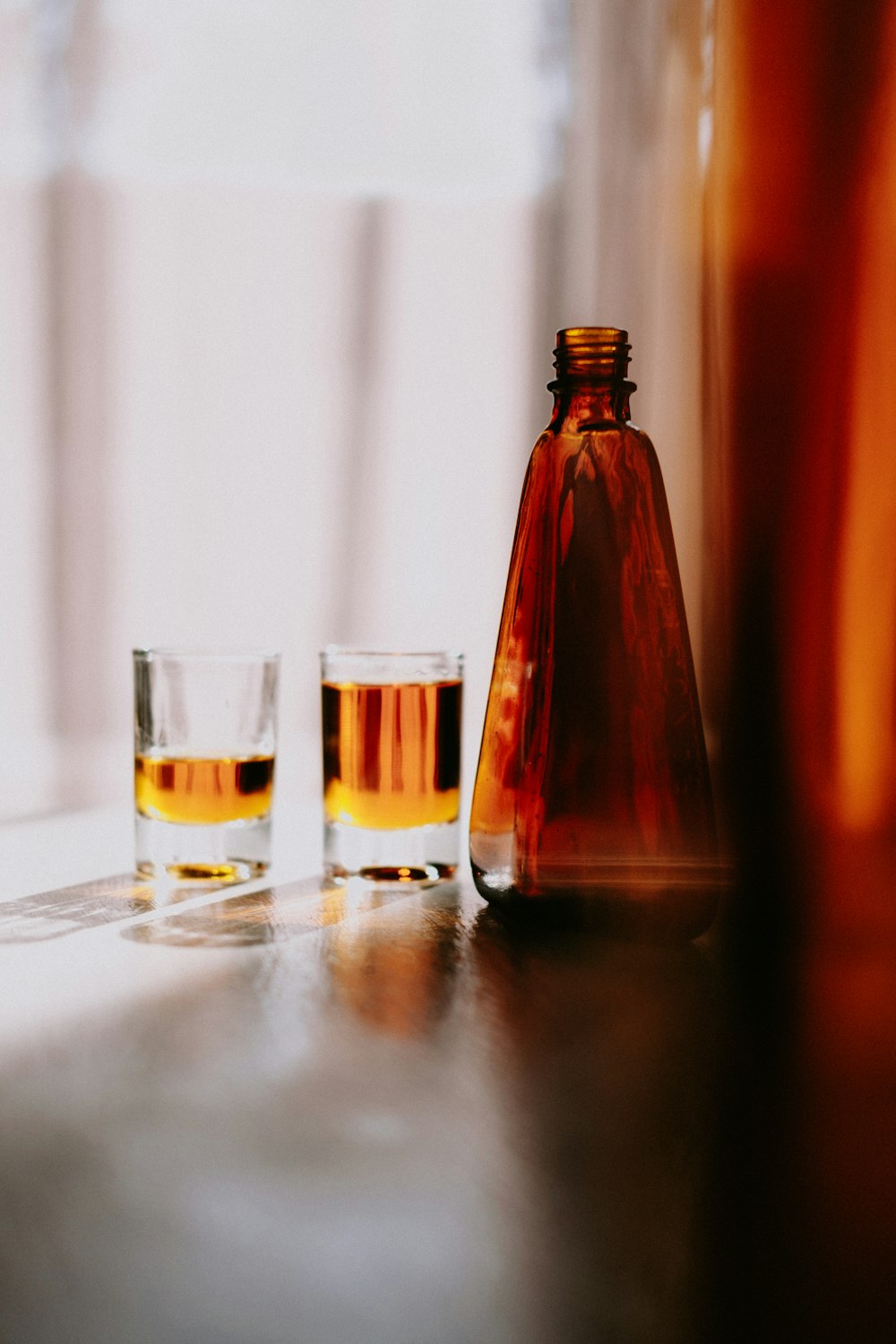 two glasses and a bottle on a table