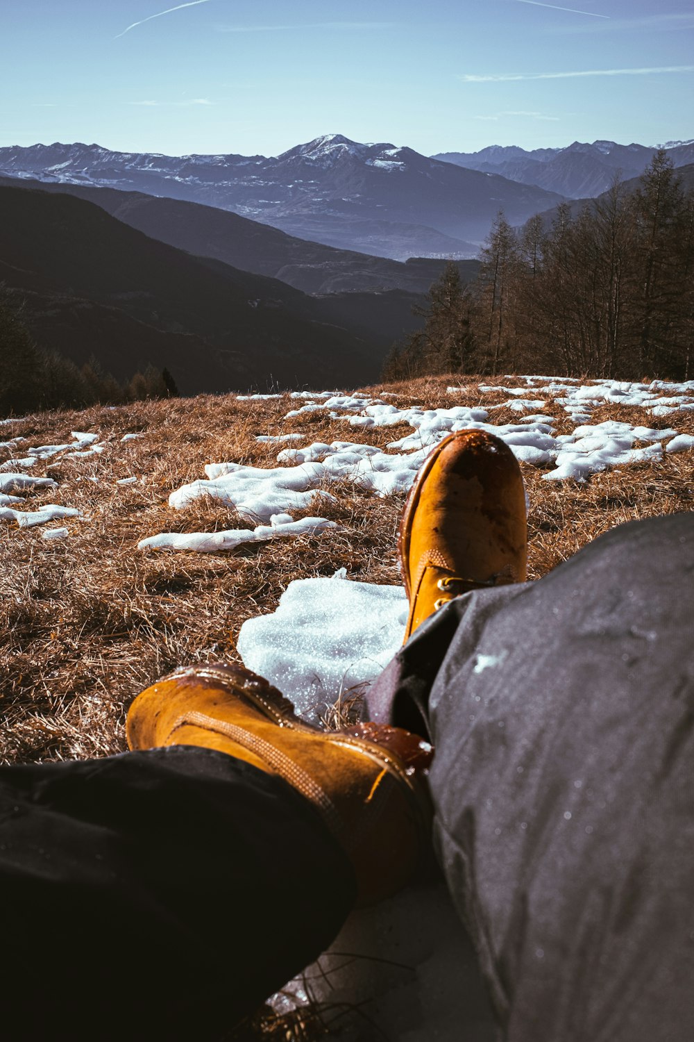 a pair of feet resting on the ground in the mountains