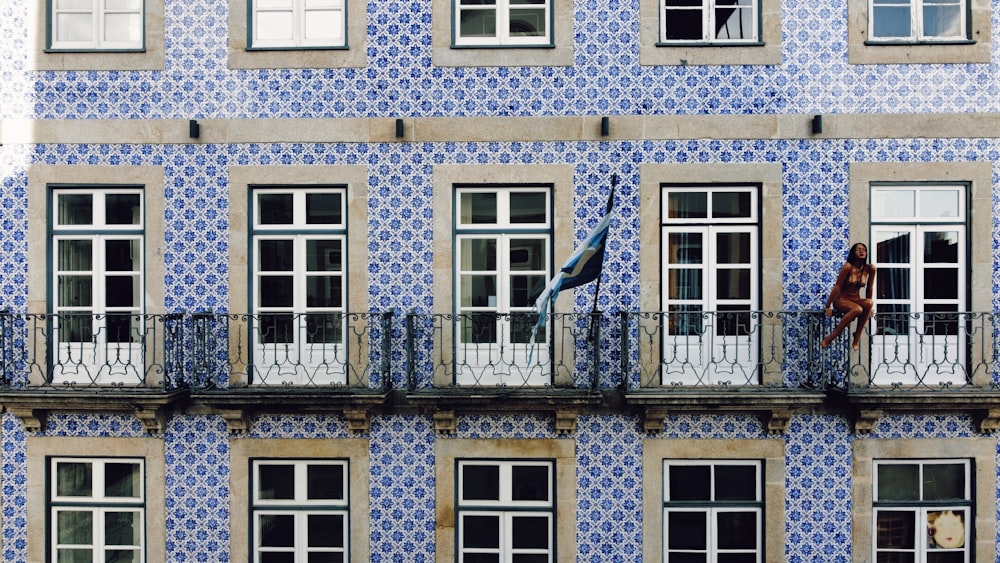 uma pessoa em pé em uma varanda de um edifício