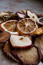 Close-up of vibrant organic dehydrated fruit slices arranged on a rustic wooden table.