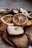 A close-up view of various dried fruit slices, including oranges, apples, and others. The texture of the dried fruits is rugged with visible details of the fruit's surface and rind. The lighting creates a warm and earthy tone.