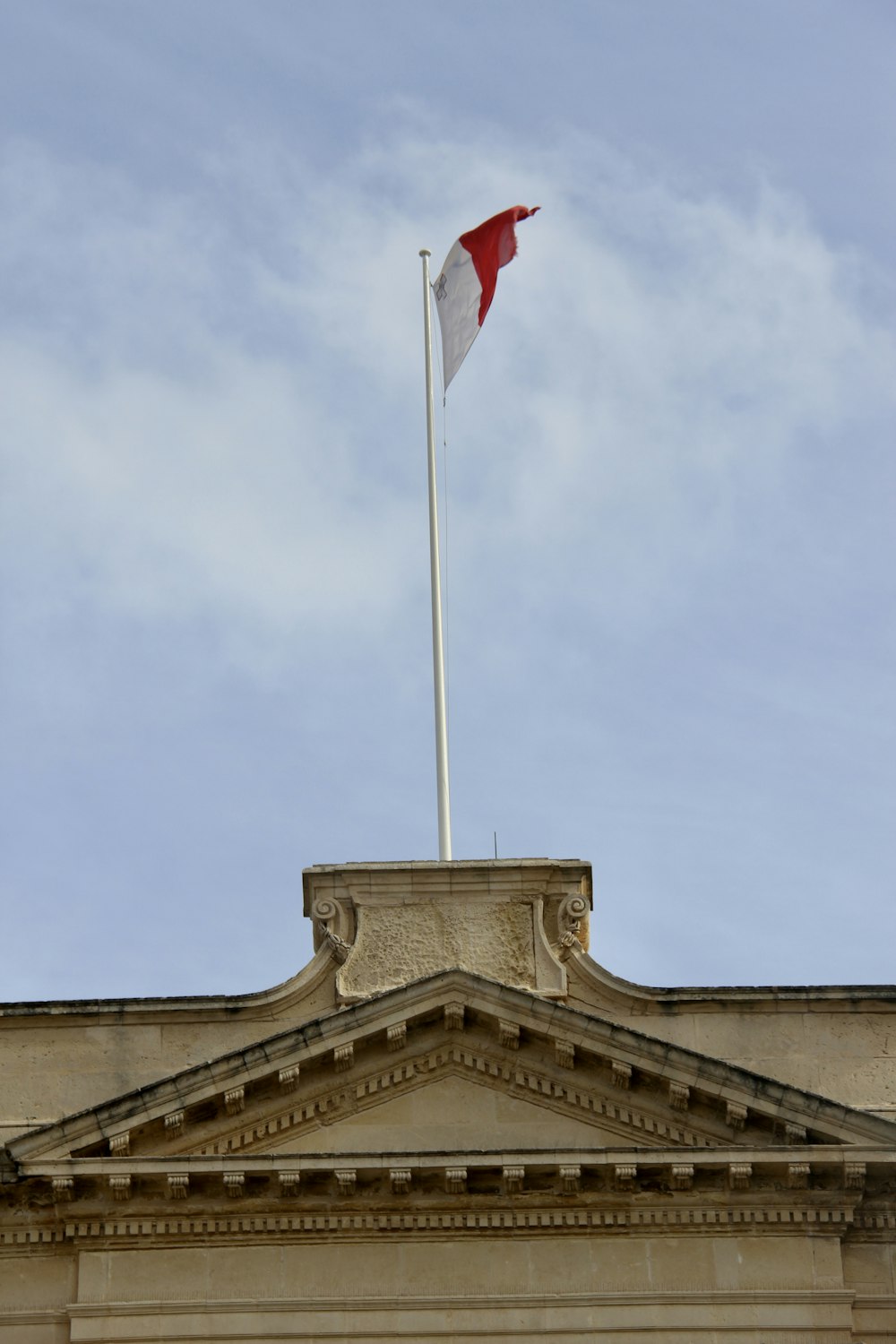 a flag on top of a building with a sky background