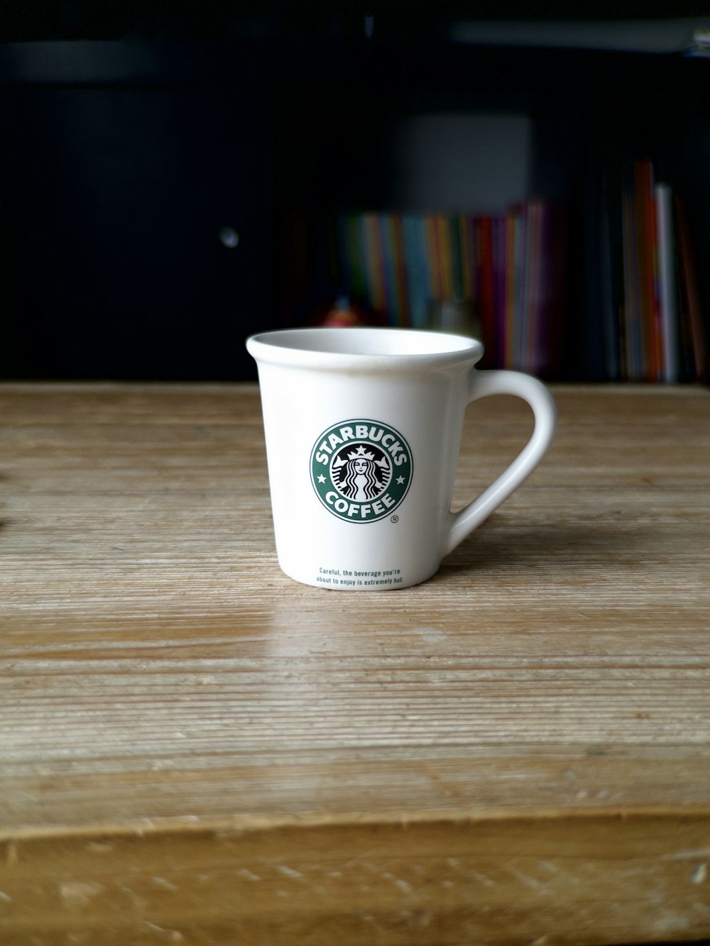 a starbucks cup sitting on top of a wooden table