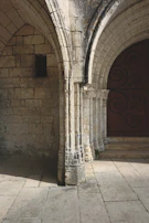 Close-up of intricate stone carvings on a centuries-old mission doorway bathed in morning light.