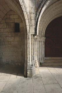 Close-up of intricate stone carvings on a centuries-old mission doorway bathed in morning light.