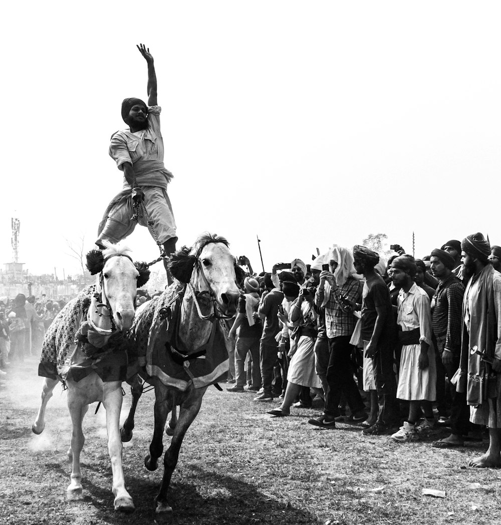 a black and white photo of a man riding a horse