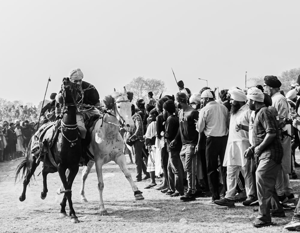 a group of people standing around a man on a horse