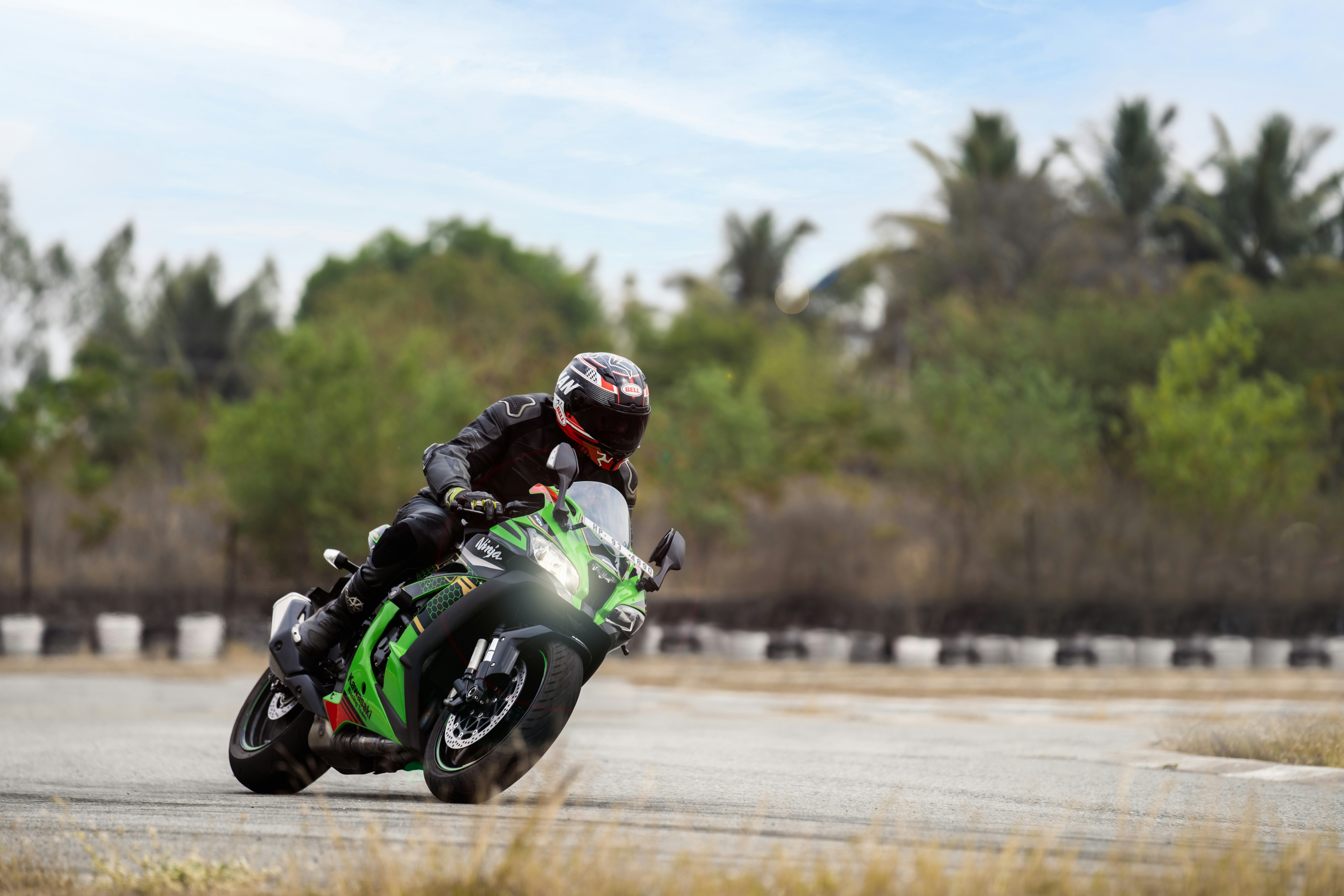 a man riding a green motorcycle down a road