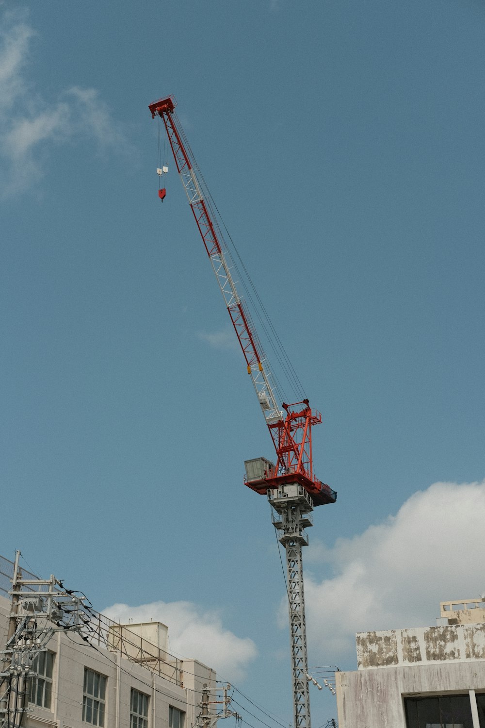 a red crane is on top of a building
