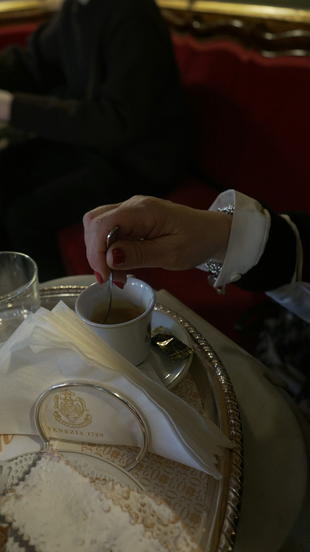 Eine Person, die mit einer Tasse Kaffee an einem Tisch sitzt