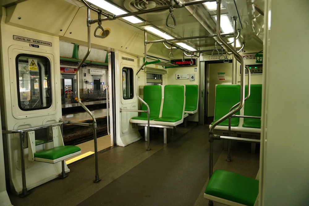 a subway car with green seats and railings