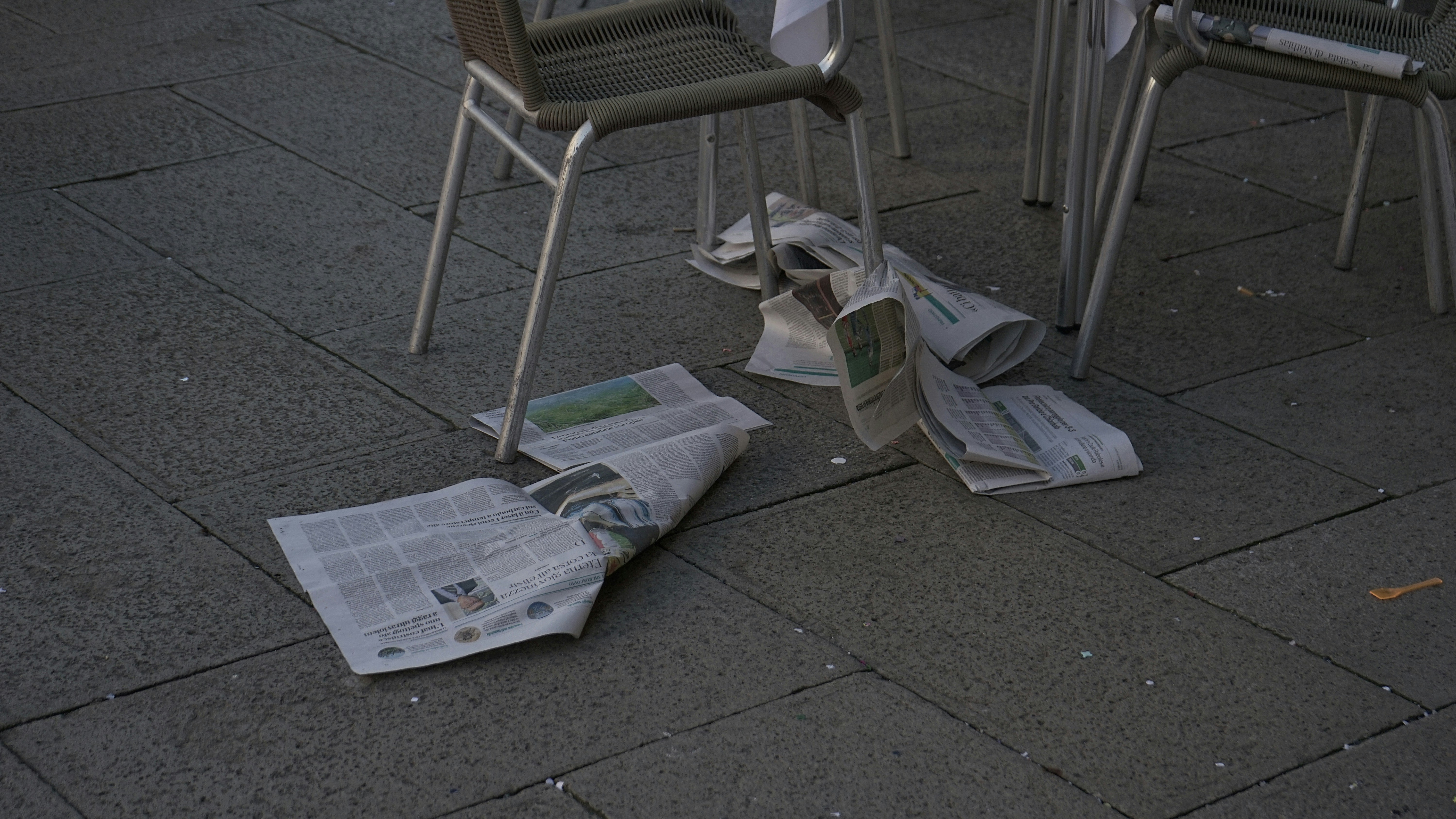 a newspaper laying on the ground next to chairs
