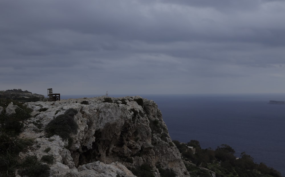 a lone bench on a cliff overlooking the ocean