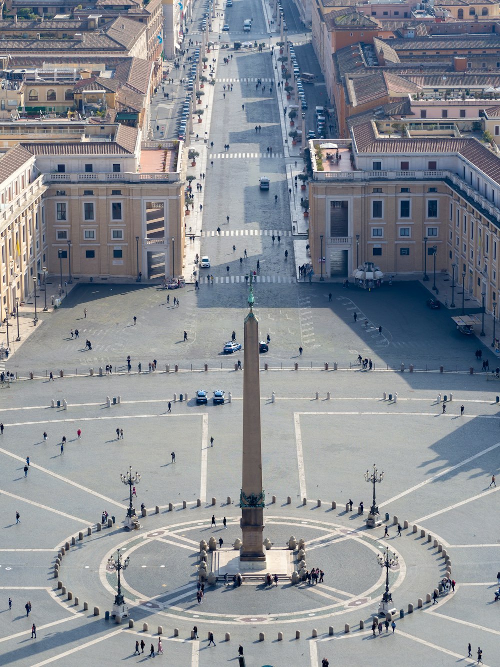 an aerial view of a city square with a monument in the middle