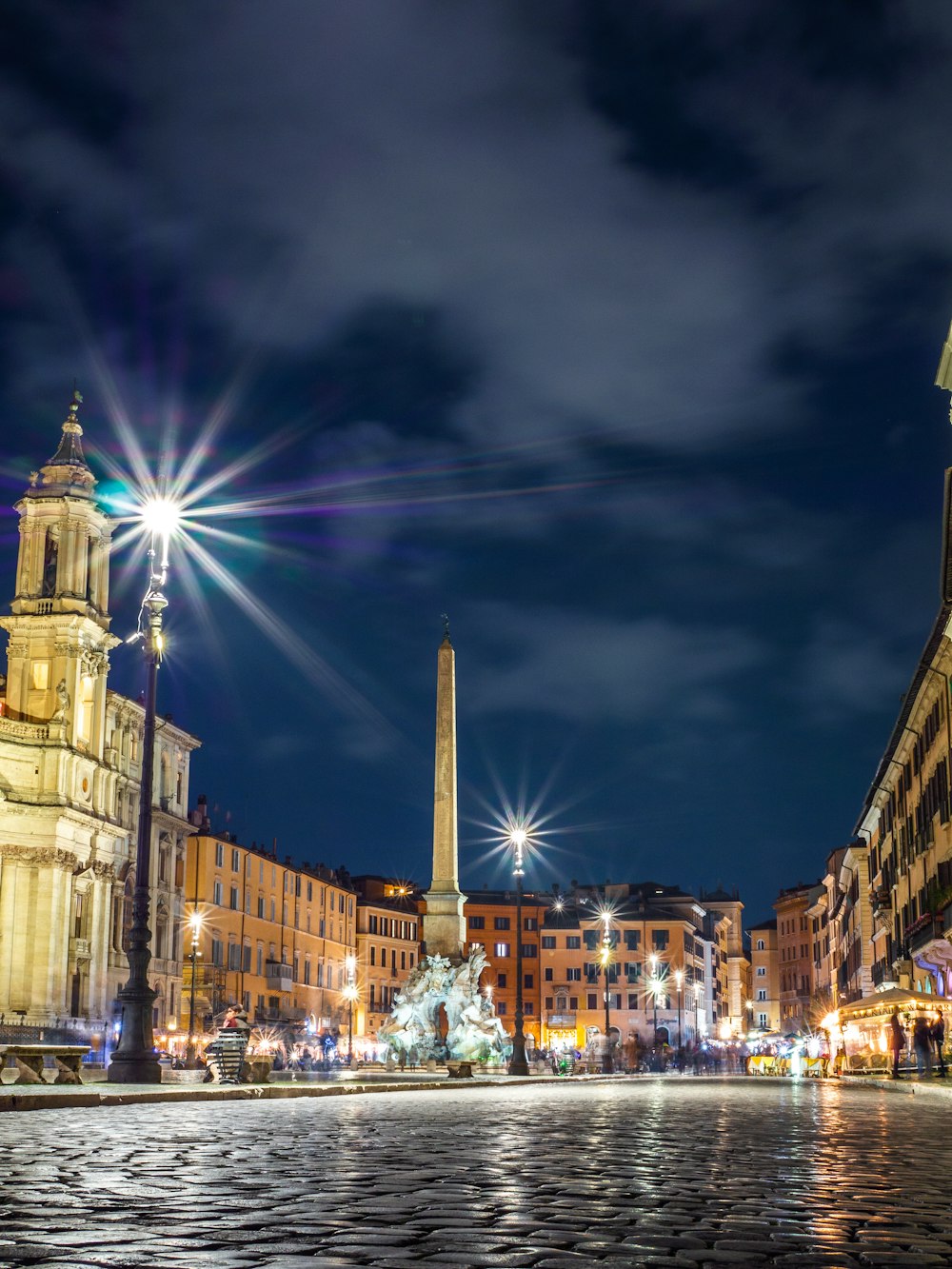 a city street at night with a clock tower in the background