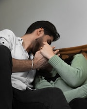 a man and a woman sitting on a bed