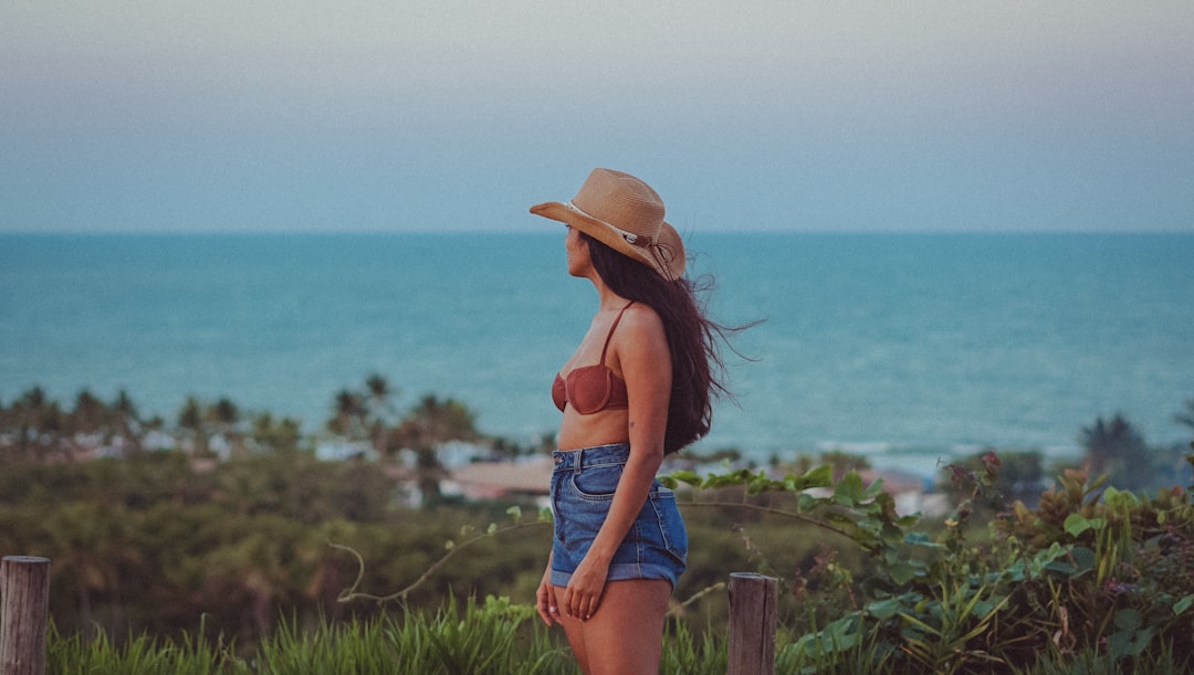 a person standing in front of a body of water, Trancoso _ Bahia.