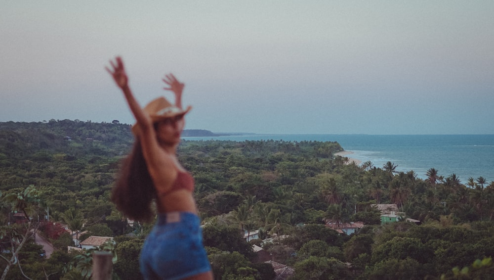 a woman standing on top of a lush green hillside