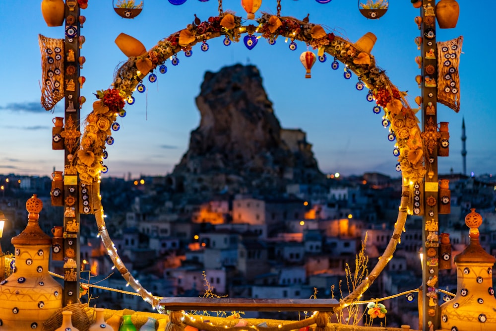 a decorated archway with lights and decorations in front of a cityscape