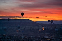 a group of hot air balloons flying over a city