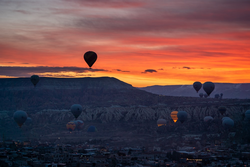 a group of hot air balloons flying over a city