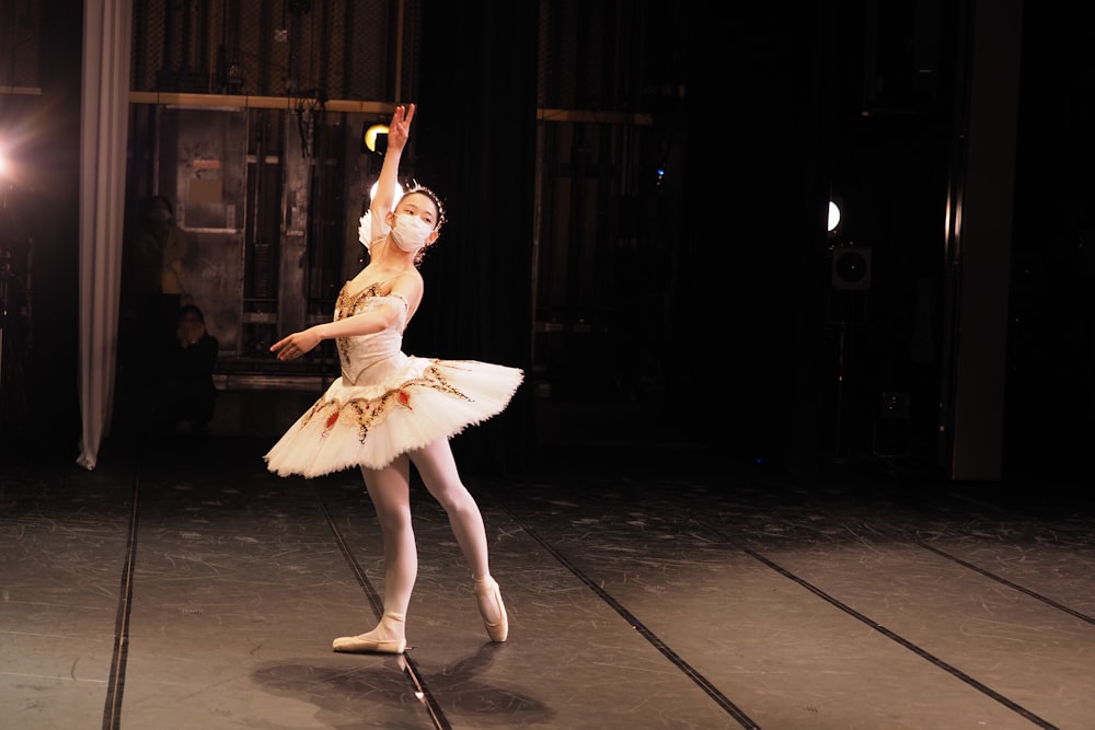 a ballerina in a white tutu and a light