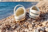 a pair of shoes sitting on top of a rocky beach