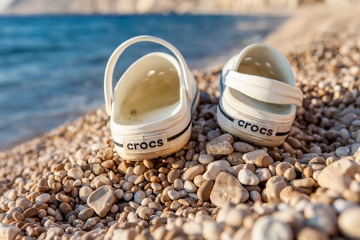a pair of shoes sitting on top of a rocky beach