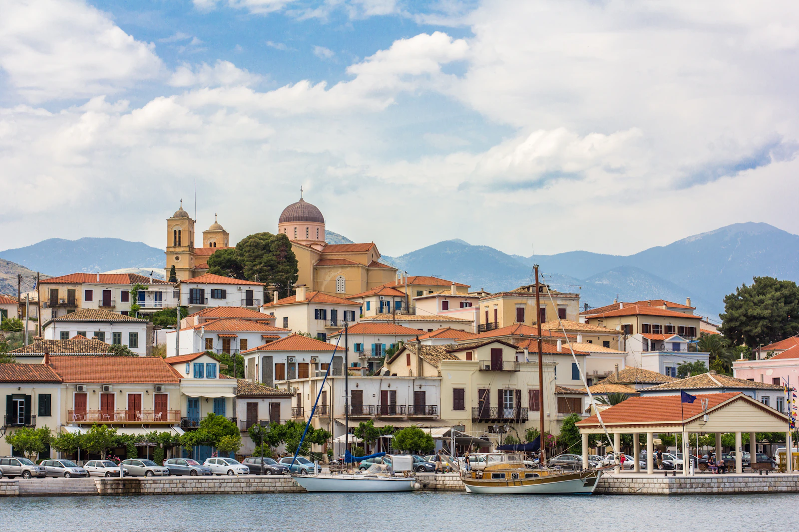A village of tiled roofs along the water below Mount Pelion