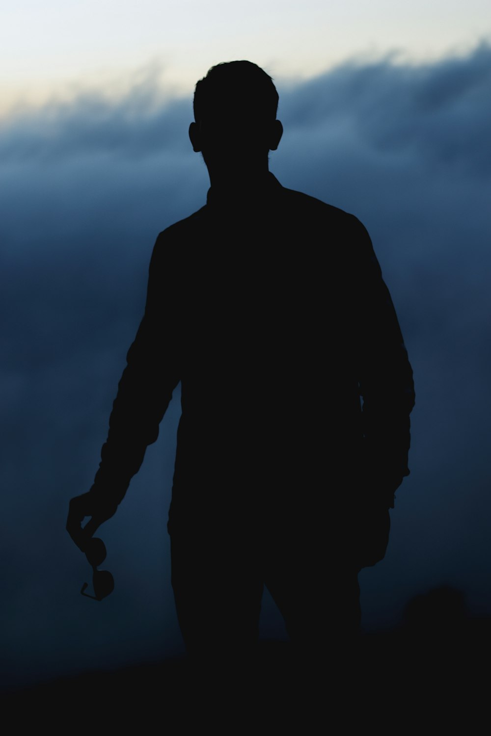 a silhouette of a man holding a cell phone