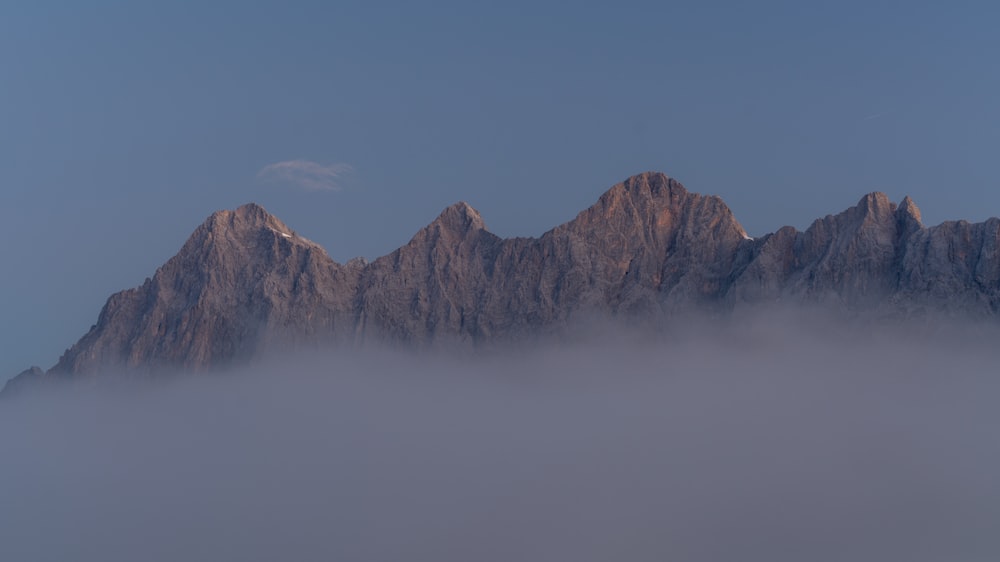 Ein sehr hoher Berg, der unter blauem Himmel nebelbedeckt ist