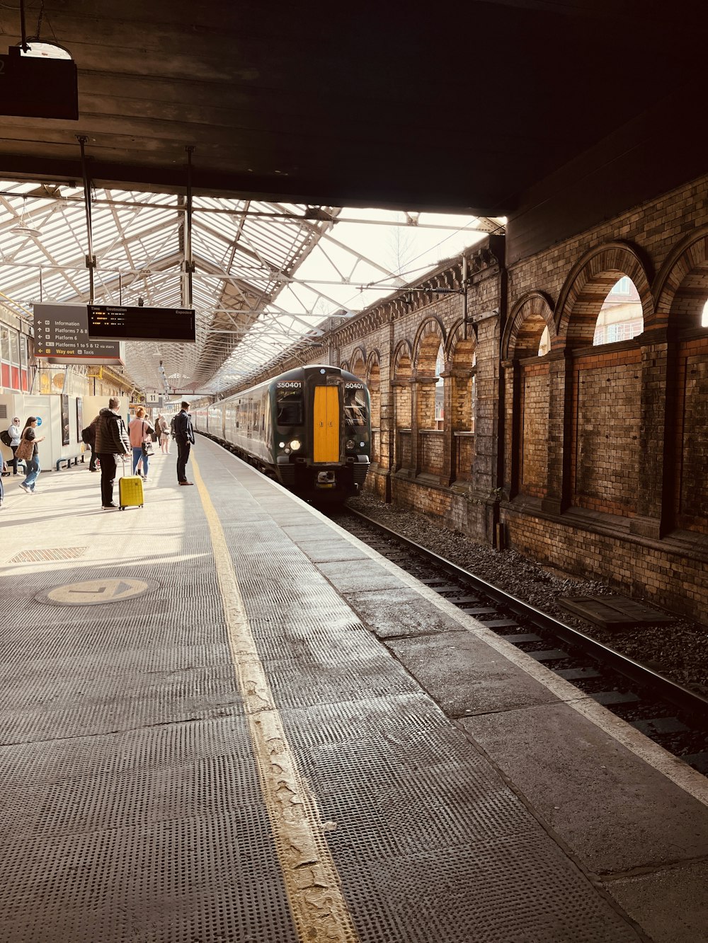 Ein Zug, der in einen Bahnhof neben einem Bahnsteig einfährt