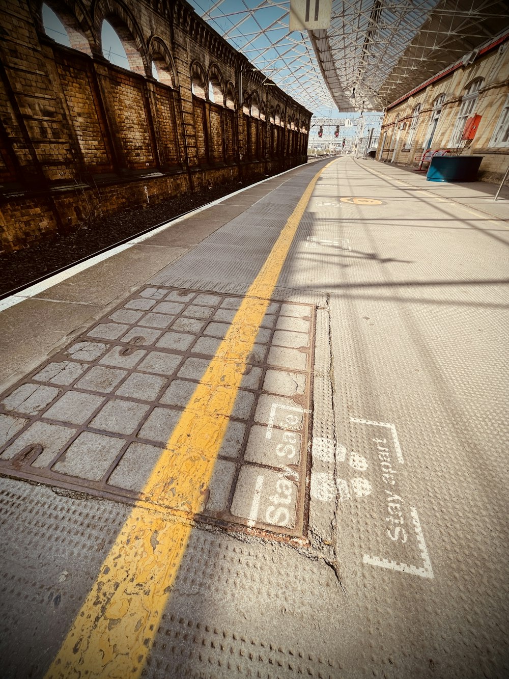 a train station with a yellow line painted on the ground