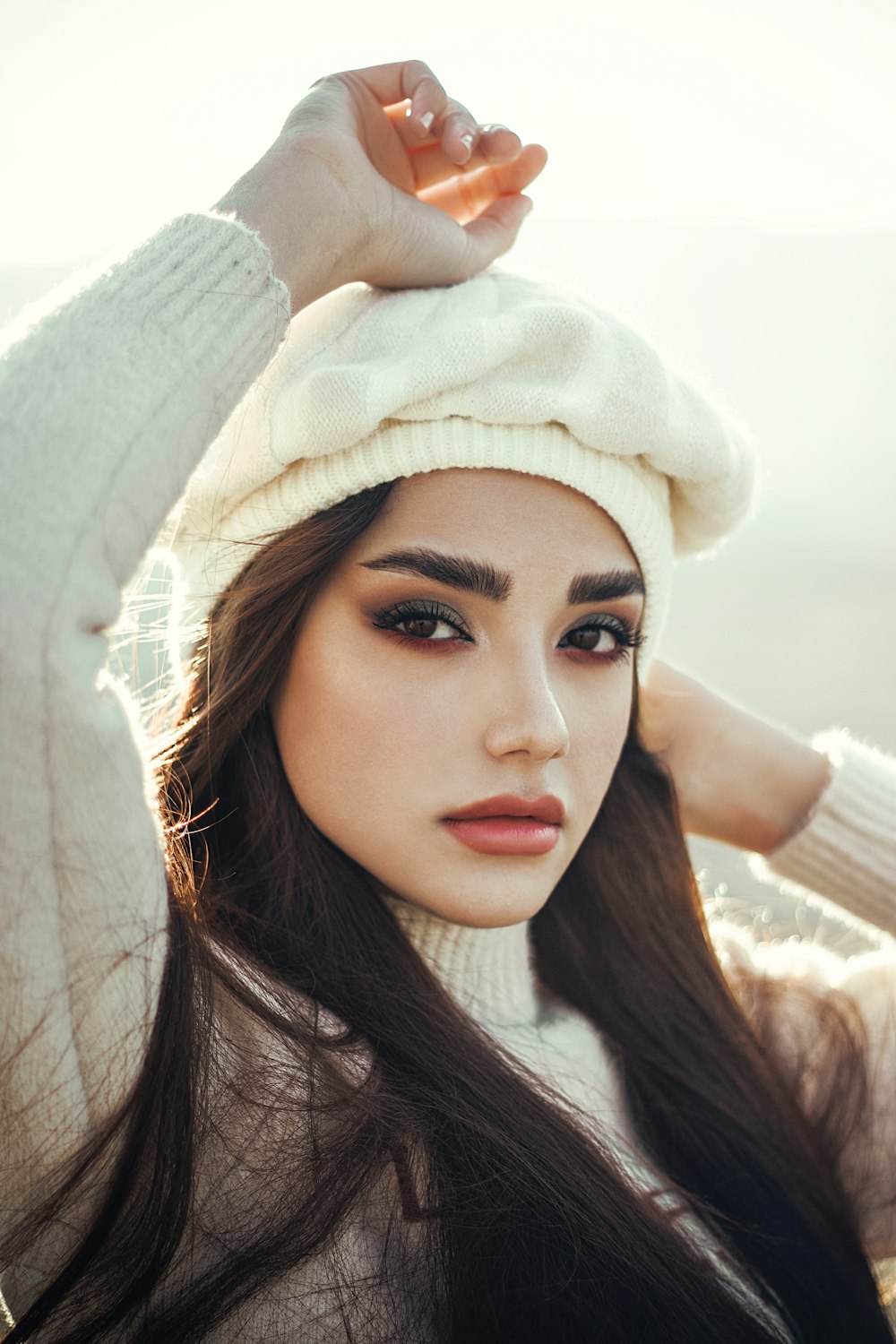 a woman with long hair wearing a white hat