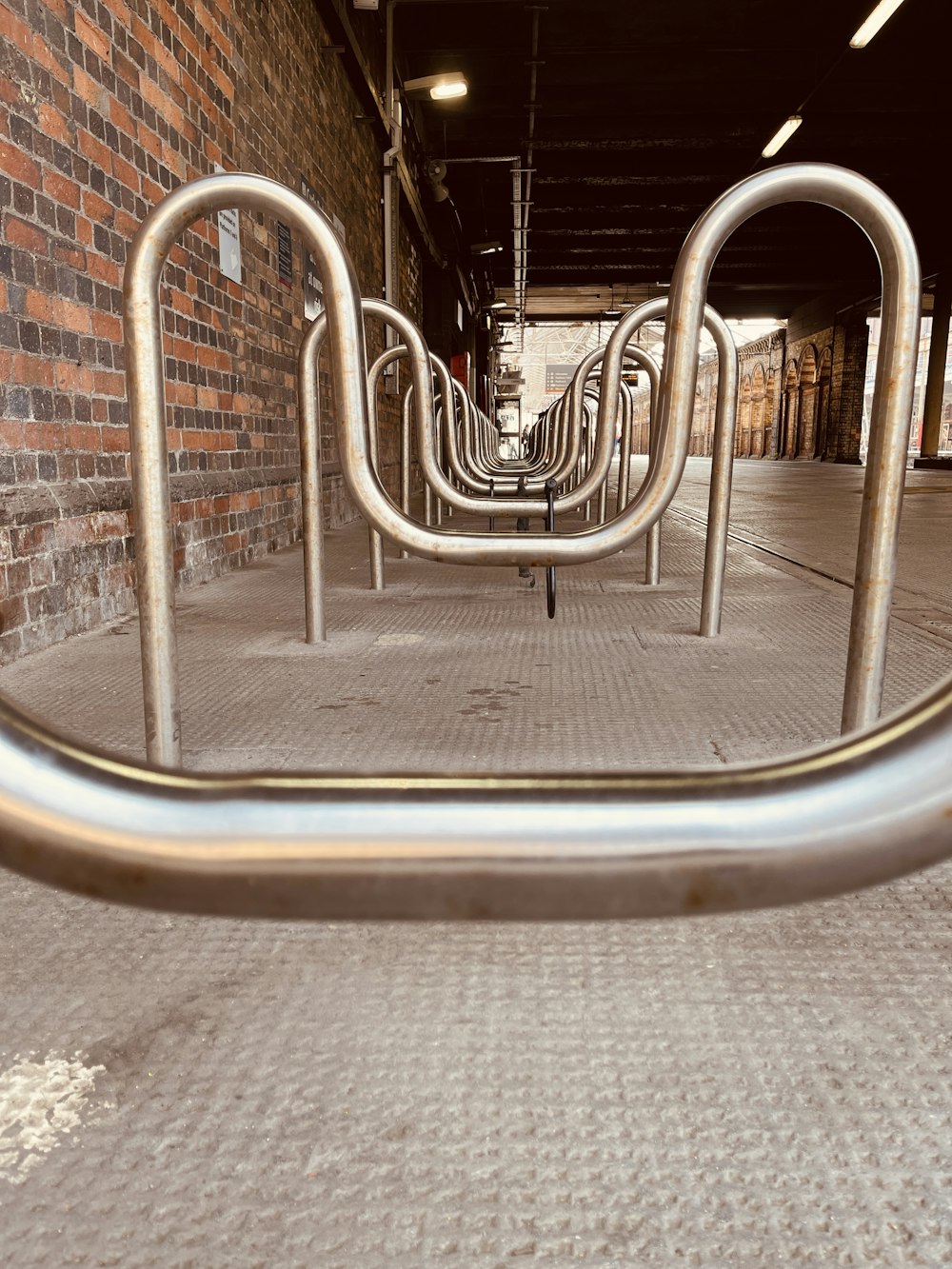 a row of metal railings in front of a brick wall